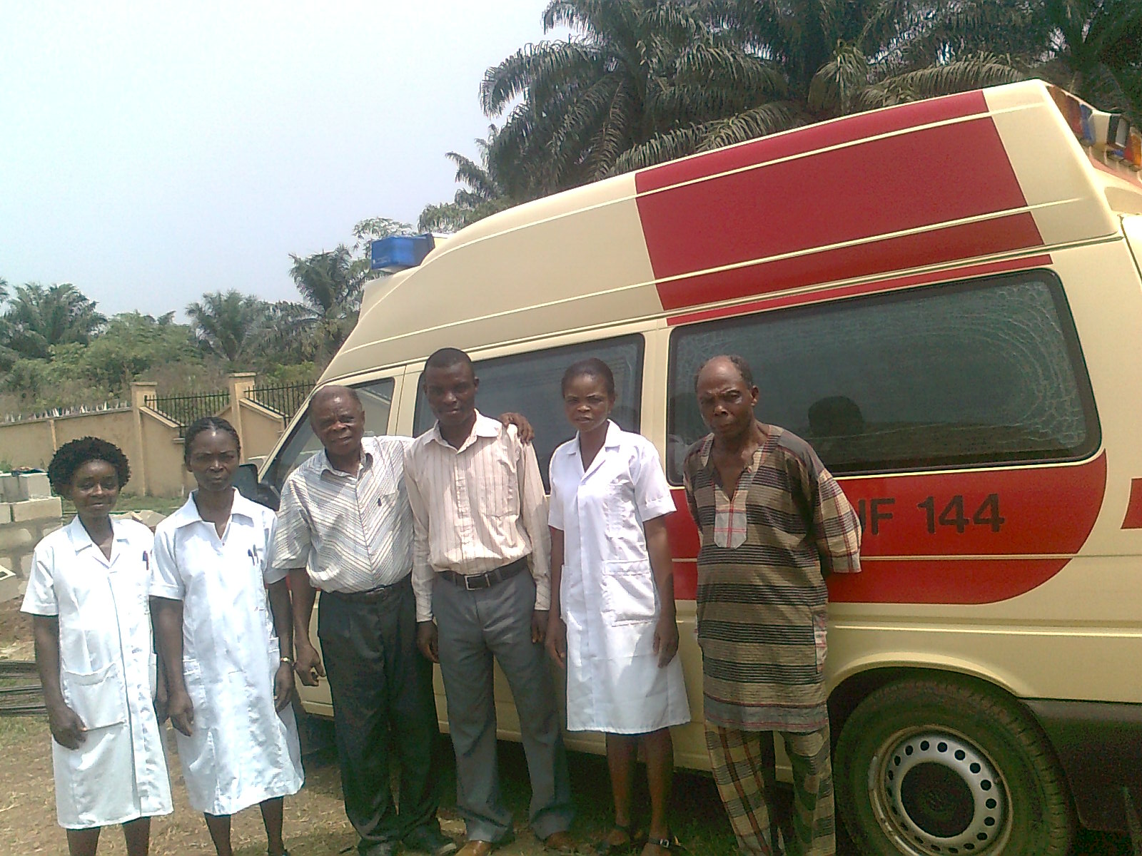 Bild von Ärzten und Krankenschwestern in Nigeria, die vor einem von HIFA gespendeten Krankentransportwagen posieren. Die mobile Krankenstation soll dazu beitragen, die Gesundheitsversorgung in ländlichen Gebieten in Nigeria zu verbessern.
