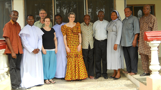 Eine Gruppe von ehrenamtlichen Verantwortlichen aus Österreich und Nigeria steht vor einem Bürogebäude in Nigeria und lächelt in die Kamera. Sie sind für die Projektentwicklung und -durchführung vor Ort verantwortlich.